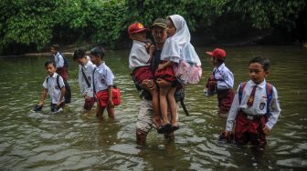 Sejumlah siswa menyeberangi Sungai Ciujung untuk sekolah di Desa Sukaluyu, Cikadu, Cianjur Selatan, Kabupaten Cianjur, Jawa Barat, Rabu (10/8/2022).  ANTARA FOTO/Raisan Al Farisi