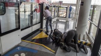 Aktor beraksi menakuti penumpang sarana transportasi Lintas Raya Terpadu (LRT) Jakarta pada wahana zombie "Train to Apocalypse" di Stasiun LRT, Jakarta, Jumat (12/8/2022).  ANTARA FOTO/Muhammad Adimaja