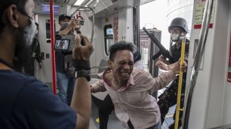 Aktor beraksi menakuti penumpang sarana transportasi Lintas Raya Terpadu (LRT) Jakarta pada wahana zombie "Train to Apocalypse" di Stasiun LRT, Jakarta, Jumat (12/8/2022).  ANTARA FOTO/Muhammad Adimaja