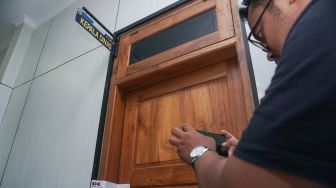 Seorang wartawan memotret pintu salah satu ruangan Dinas Kominfo Kabupaten Pemalang yang telah disegel oleh KPK di Pemda Kabupaten Pemalang, Jawa Tengah, Kamis (11/8/2022).  ANTARA FOTO/Harviyan Perdana Putra