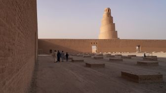 Pengunjung melihat Menara Spiral Malwiya yang berada di kompleks Masjid Agung Samarra, Baghdad, Irak, Selasa (26/7/2022). [Ismail ADNAN/AFP]