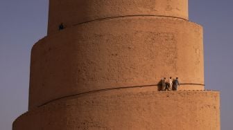 Pengunjung menaiki Menara Spiral Malwiya yang berada di kompleks Masjid Agung Samarra, Baghdad, Irak, Selasa (26/7/2022). [Ismail ADNAN/AFP]