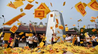 Warga etnis Tionghoa melemparkan uang kertas (persembahan) pada perayaan Hungry Ghost Festival di Vihara Gunung Timur Medan, Kota Medan, Sumatera Utara, Jumat (12/8/2022). [ANTARA FOTO/Fransisco Carolio/Ief/rwa]
