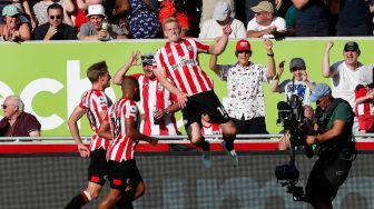 Bek Brentford Ben Mee (tengah) berselebrasi setelah mencetak gol saat pertandingan sepak bola Liga Premier Inggris antara Brentford dan Manchester United di Stadion Brentford Community, London, Inggris, Sabtu (13/8/2022). [Ian Kington / AFP]