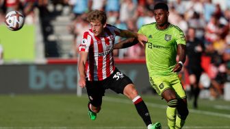 Bek Brentford Mads Roerslev (kiri) bersaing dengan striker Manchester United Marcus Rashford (kanan) saat pertandingan sepak bola Liga Premier Inggris antara Brentford dan Manchester United di Stadion Brentford Community, London, Inggris, Sabtu (13/8/2022). [Ian Kington / AFP]
