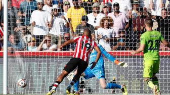 Gelandang Brentford Bryan Mbeumo (tengah) menembak bola melewati kiper Manchester United David de Gea untuk mencetak gol saat pertandingan sepak bola Liga Premier Inggris antara Brentford dan Manchester United di Stadion Brentford Community, London, Inggris, Sabtu (13/8/2022). [Ian Kington / AFP]
