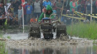 Peserta memacu kecepatan traktor saat mengikuti perlombaan balap traktor di Karangduren, Kebonarum, Klaten, Jawa Tengah, Minggu (14/8/2022). [ANTARA FOTO/Aloysius Jarot Nugroho/hp]