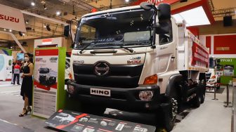 Sales Promotion Girl (SPG) berpose di depan Truk Hino Euro4 200 yang dipamerkan pada ajang pameran otomotif Gaikindo Indonesia International Auto Show (GIIAS) 2022 di Indonesia Convention Exhibition (ICE) BSD, Serpong, Tangerang, Banten, Sabtu (13/8/2022). [Suara.com/Alfian Winanto]