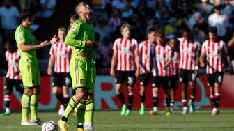 Reaksi Striker Manchester United Cristiano Ronaldo ketika para pemain Brentford merayakan gol mereka saat pertandingan sepak bola Liga Premier Inggris antara Brentford dan Manchester United di Stadion Brentford Community, London, Inggris, Sabtu (13/8/2022). [Ian Kington / AFP]