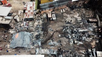 Foto udara saat petugas Dinas Pemadam Kebakaran Kota Jambi melakukan pendinginan saat terjadi kebakaran di salah satu gudang minyak di Jambi, Senin (15/8/2022). [ANTARA FOTO/Wahdi Septiawan/foc]