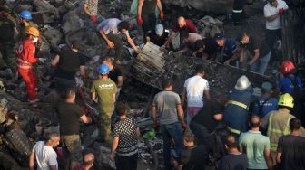 Petugas penyelamat dan sukarelawan membersihkan puing-puing kebakaran di Pasar Surmalu, Yerevan, Armenia, Minggu (14/8/2022). [Karen MINASYAN / AFP]