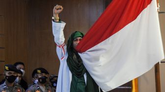 Terdakwa kasus dugaan penyebaran berita bohong Bahar Bin Smith mencium bendera merah putih saat menjalani sidang lanjutan dengan agenda pembacaan putusan di Pengadilan Negeri Bandung, Jawa Barat, Selasa (16/8/2022).  ANTARA FOTO/Raisan Al Farisi