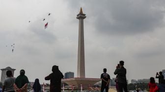 Helikopter gabungan milik TNI-Polri terbang melintas dengan bendera merah putih raksasa di atas Monas saat Peringatan Detik-Detik Proklamasi di Perpustakaan Nasional, Jakarta Pusat, Rabu (17/8/2022). [Suara.com/Alfian Winanto]
