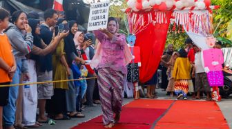 Peserta berpose saat mengikuti acara &#039;Ciliwung Fashion Week&#039; di Kebon Baru, Jakarta Selatan, Rabu (17/8/2022). [Suara.com/Alfian Winanto]