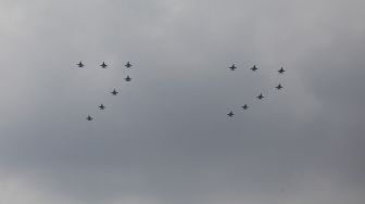 Pesawat Tempur F-16 TNI AU terbang membentuk formasi angka 77 di atas langit saat Peringatan Detik-Detik Proklamasi di Perpustakaan Nasional, Jakarta Pusat, Rabu (17/8/2022). [Suara.com/Alfian Winanto]