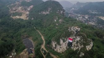 Foto udara pengibaran bendera Merah Putih raksasa saat upacara kemerdekaan di Geotheater Tebing Hawu, Padalarang, Kabupaten Bandung Barat, Jawa Barat, Rabu (17/8/2022). ANTARA FOTO/Raisan Al Farisi
