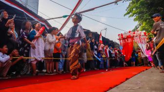 Peserta berpose saat mengikuti acara 'Ciliwung Fashion Week' di Kebon Baru, Jakarta Selatan, Rabu (17/8/2022). [Suara.com/Alfian Winanto]