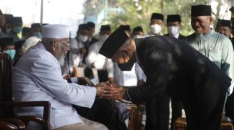 Menko PMK Muhadjir Effendy (kanan) bersalaman dengan pendiri Pondok Pesantren Islam Al Mukmin Ngruki Abu Bakar Ba&#039;asyir (kiri) saat upacara HUT Kemerdekaan ke-77 RI di ponpes setempat, Ngruki, Sukoharjo, Jawa Tengah, Rabu (17/8/2022). ANTARA FOTO/Maulana Surya
