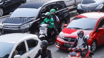 Pengemudi ojek online membawa penumpang di Jalan Gatot Subroto, Jakarta Selatan, Kamis (18/8/2022). [Suara.com/Alfian Winanto]