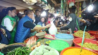 Menteri Perdagangan Zulkifli Hasan didampingi Director of Central Public Affairs at Grab Indonesia Tirza R Munusamy berbincang dengan pembeli saat berkunjung di Pasar Tomang Barat, Jakarta, Kamis (18/8/2022).  
