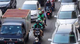 Pengemudi ojek online membawa penumpang di Jalan Gatot Subroto, Jakarta Selatan, Kamis (18/8/2022). [Suara.com/Alfian Winanto]