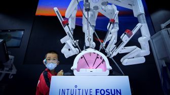 Pengunjung melihat lengan robot yang didesain untuk operasi pada acara Konferensi Robot Dunia 2022 di Beijing, China, Kamis (18/8/2022). [WANG Zhao/AFP]