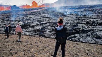 Sejumlah orang mengunjungi lokasi erupsi Gunung Fagradalsfjall di Grindavik, Islandia, Kamis (4/8/2022). [Jeremie RICHARD / AFP]