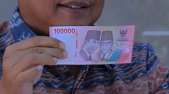 Kepala Bank Indonesia (BI) Perwakilan wilayah NTT I Nyoman Ariawan Atmaja menunjukkan uang kertas baru pecahan Rp100 ribu (kiri) dan pecahan Rp100 ribu lama saat peluncurannya di Kota Kupang, NTT, Kamis (18/8/2022). [ANTARA FOTO/Kornelis Kaha/rwa]