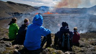 Sejumlah orang mengunjungi lokasi erupsi Gunung Fagradalsfjall di Grindavik, Islandia, Kamis (4/8/2022). [Jeremie RICHARD / AFP]
