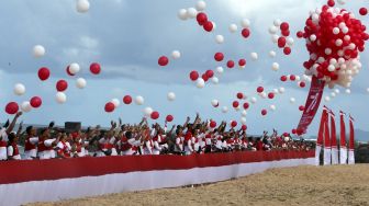 Peserta gowes merah putih melepas balon di pantai wisata pulau Kapuk, Lhoknga, Aceh Besar, Aceh, Sabtu (20/8/2022). ANTARA FOTO/Irwansyah Putra
