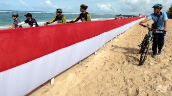 Peserta gowes merah putih melintas diantara bendera merah putih di pantai wisata pulau Kapuk, Lhoknga, Aceh Besar, Aceh, Sabtu (20/8/2022).  ANTARA FOTO/Irwansyah Putra