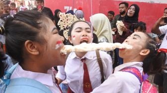 Sejumlah warga mengikuti lomba makan kerupuk di Kelurahan Ardirejo, Panji, Situbondo, Jawa Timur, Minggu (21/8/2022). ANTARA FOTO/Seno
