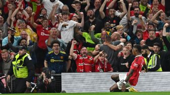 Striker Manchester United Inggris Marcus Rashford (kanan) merayakan golnya di depan pendukung setelah mencetak gol kedua mereka selama pertandingan sepak bola Liga Premier Inggris antara Manchester United melawan Liverpool di Old Trafford, Selasa (23/8/2022) dini hari WIB.
Paul ELLIS / AFP


