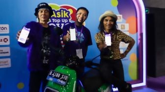 Chief Operating Officer Ovo Eddie Martono (tengah) bersama personil grup band Slank Bimbim (kiri) dan Kaka (kanan) menunjukkan tampilan layar aplikasi usai melakukan pengisian dana saat acara 'Asik Top Up Ovo di Mana Saja' di M Bloc Space, Jakarta Selatan, Selasa (23/8/2022). [Suara.com/Alfian Winanto]