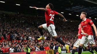 Striker Manchester United Jadon Sancho (tengah) merayakan golnya setelah mencetak gol pembuka selama pertandingan sepak bola Liga Premier Inggris antara Manchester United melawan Liverpool di Old Trafford, Selasa (23/8/2022) dini hari WIB. Paul ELLIS / AFP
