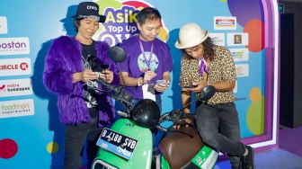 Chief Operating Officer Ovo Eddie Martono (tengah) bersama personil grup band Slank Bimbim (kiri) dan Kaka (kanan) melakukan isi ulang saldo melalui aplikasi saat acara 'Asik Top Up Ovo di Mana Saja' di M Bloc Space, Jakarta Selatan, Selasa (23/8/2022). [Suara.com/Alfian Winanto]