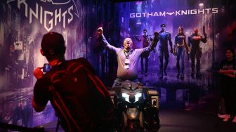 Pengunjung berswafoto di stan game 'Gotham Knights' dsaat pameran video game Gamescom di Cologne, Jerman, Rabu (24/8/2022). [Ina FASSBENDER / AFP]
