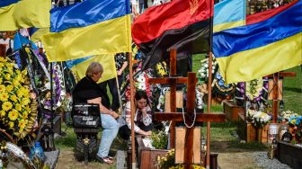 Warga memberi penghormatan selama upacara untuk tentara Ukraina yang gugur ddi Pemakaman Lychakiv, Lviv, Ukraina, Rabu (24/8/2022). [YURIY DYACHYSHYN / AFP]
