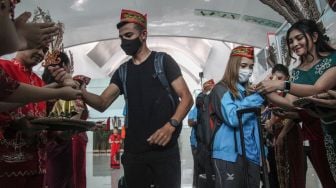 Pembalap sepeda MTB Dann Noyola asal Jerman (kiri) dan Natalie Panyawan asal Thailand (kanan) dipasangkan gelang Lilis Lamiang Dayak saat tiba di Bandara Tjilik Riwut Palangka Raya, Kalimantan Tengah, Rabu (24/8/2022). [ANTARA FOTO/Makna Zaezar/aww]