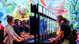 Pengunjung memainkan game 'Park Beyond', sebuah video game yang diterbitkan oleh Bandai Namco Entertainment, saat pameran video game Gamescom di Cologne, Jerman, Rabu (24/8/2022). [Ina FASSBENDER / AFP]
