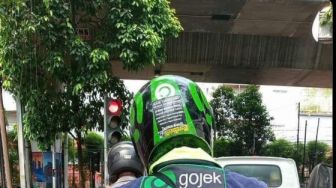 Potret Ojol Berhenti di Lampu Merah Bikin Publik Salut, Tulisan di Balik Jaket Jadi Sorotan