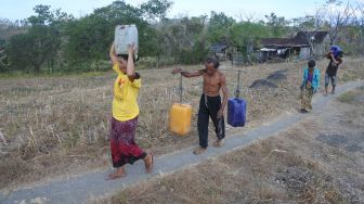 Sejumlah warga membawa air bersih yang didistribusikan di Desa Jatisari, Arjasa, Situbondo, Jawa Timur, Kamis (25/8/2022). [ANTARA FOTO/Seno/hp]