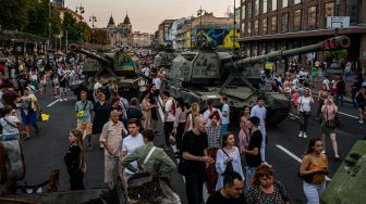 Orang-orang melihat peralatan militer Rusia yang hancur di jalan Khreshchatyk, Kyiv, Ukraina, Minggu (21/8/2022). [Dimitar DILKOFF / AFP]