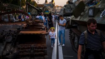 Orang-orang melihat peralatan militer Rusia yang hancur di jalan Khreshchatyk, Kyiv, Ukraina, Selasa (23/8/2022). [Dimitar DILKOFF / AFP]
