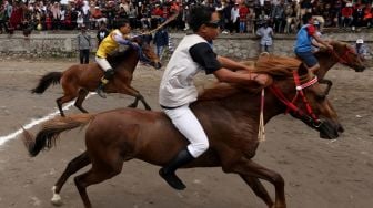 Para joki memacu kudanya pada tradisi pacuan kuda tradisional Gayo di lapangan HM Hasan, Blang Bebangka, Aceh Tengah, Aceh, Sabtu (27/8/2022). [ANTARA FOTO/Irwansyah Putra/tom]