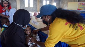 Dokter (kanan) memeriksa kesehatan seorang anak pada kegiatan pengobatan massal gratis di Kampus STIKES Papua, Kota Sorong, Papua Barat, Sabtu (27/8/2022). [ANTARA FOTO/Olha Mulalinda/tom]