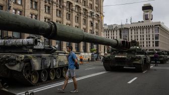 Seorang pria melihat peralatan militer Rusia yang hancur di jalan Khreshchatyk, Kyiv, Ukraina, Sabtu (20/8/2022). [Dimitar DILKOFF / AFP]