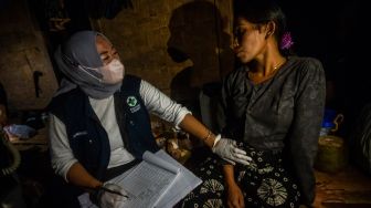 Bidan Puskesmas Cisimeut memeriksa kehamilan dari seorang ibu Suku Baduy di Kampung Cisadane, Lebak, Banten, Jumat (26/8/2022) malam. [ANTARA FOTO/Muhammad Bagus Khoirunas/wsj]
