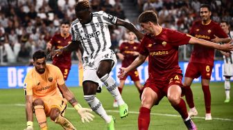 Penyerang Juventus Moise Kean (kedua kiri) menantang kiper AS Roma Rui Patricio (kiri) meskipun bek AS Roma dari Albania Marash Kumbulla (kanan) selama pertandingan sepak bola Serie A Italia antara Juventus melawan AS Roma  di Stadion Allianz, Minggu (28/8/2022) dini hari WIB.
Marco BERTORELLO / AFP

