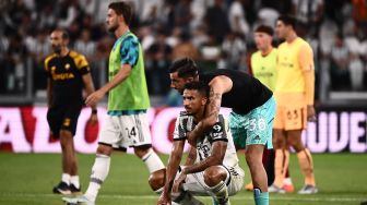 Penjaga gawang Juventus Mattia Perin (kanan) menghibur bek Juventus Danilo pada akhir pertandingan sepak bola Serie A Italia antara Juventus melawan AS Roma  di Stadion Allianz, Minggu (28/8/2022) dini hari WIB. Marco BERTORELLO / AFP
